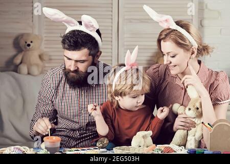 Vater, Mutter und Sohn malen osterei in Hasenohren. Stockfoto