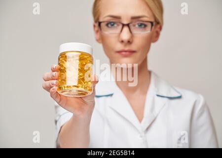 Health Care und Diät-Konzept - Arzt Ernährungsberater oder Kardiologe Fischöl in Kapseln für Vitamin D und Omega-3 halten Fettsäuren Stockfoto