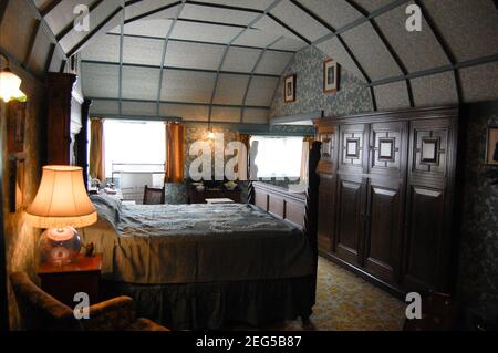 Cragside Northumberland UK Schlafzimmer große Eichenbalken Holzbalken gebogene viktorianische Lampe beleuchtet große Sitzbilder Wandbilder Papier Kunstwand Stockfoto