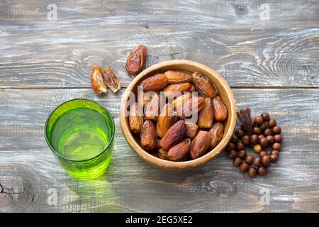 Getrocknete Datteln Früchte und ein Glas Wasser auf einem Holztisch. Traditionelle Fast Breaking, Muslime Abendessen während des heiligen Ramadan Stockfoto