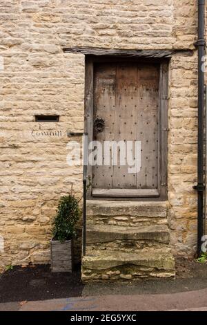 Verwitterte alte hölzerne Haustür von Steinhütte, Minchinhampton, Gloucetershire, Großbritannien Stockfoto