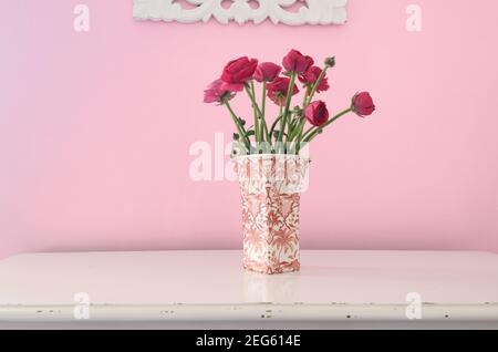 Stillleben von roten Rosen in rosa & weiße Vase Auf Rosa Hintergrund Setzen Stockfoto