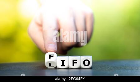 Hand dreht Würfel und ändert das Akronym LIFO (Last in First Out) zu FIFO (First in First Out). Stockfoto