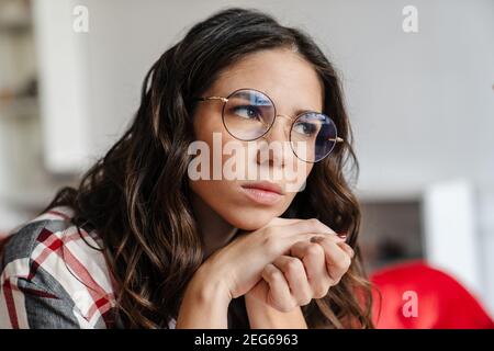 Nahaufnahme Porträt einer nachdenklichen jungen Frau in Innenräumen, wegschauen, denken Stockfoto