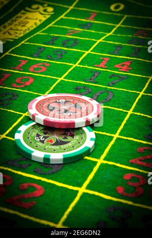 Glücksspiel Chips, FranceColorful Casino Chips auf einem pulsierenden Roulette-Tisch während eines Abendspiels in einer belebten Spielhalle Stockfoto