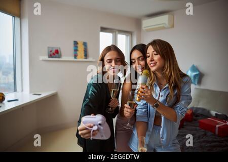 Fröhliche Dame, die mit ihren Freunden ein Video dreht Stockfoto