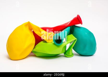 Farbenfrohe Ballons in einer verspielten Anordnung auf weißem Hintergrund, die ihre lebendigen Farben und Texturen zeigen Stockfoto