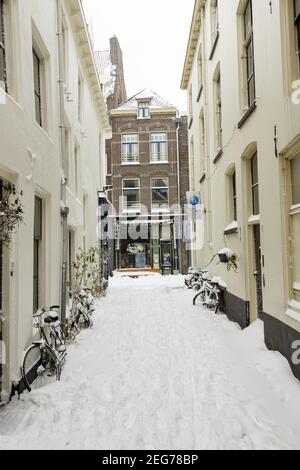 ZUTPHE, NIEDERLANDE - 08. Feb 2021: Kleine Gasse mit dichtem Schneesack im historischen Zentrum der mittelalterlichen Hansestadt Stockfoto