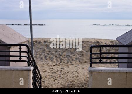 Der Eingang zu einem Badehaus durch ein Tor mit einem Metallgeländer am Strand (Pesaro, Italien, Europa) Stockfoto