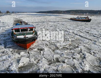 Schwedt, Deutschland. Februar 2021, 18th. Ein deutscher (l) und ein polnischer Eisbrecher navigieren auf der deutsch-polnischen Grenzfluß oder. Drifteis erhöht die Überschwemmungsgefahr in einigen Abschnitten der oder. Derzeit fahren mehrere deutsche und polnische Eisbrecher stromaufwärts, um die geschlossene Eisdecke aufzubrechen. Quelle: Patrick Pleul/dpa-Zentralbild/ZB/dpa/Alamy Live News Stockfoto