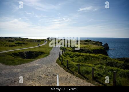 NORMANDIE, FRANKREICH - 4. Juli 2017: Touristen besuchen die Bombe Crater Riddled Cliffs in Pointe du Hoc, aus der Schlacht der Normandie Landungen durin Stockfoto