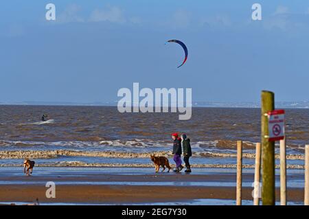 Weston Super Mare, Großbritannien. Februar 2021, 18th. UK Wetter an einem kalten und sonnigen Morgen nimmt ein einmüiger Windsurfer an der Weston Super Mare Strandpromenade in North Somerset zum Meer. Bild: Robert Timoney/Alamy Live News Stockfoto