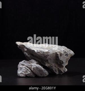 Stein Podium für Verpackung und kosmetische Präsentation auf schwarzem Hintergrund, quadratisch. Stockfoto