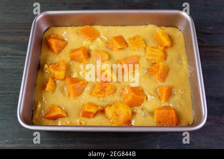 Butternut Squash Kuchen Teig in einer Kuchenform gekrönt mit Gewürfelte Squashes bereit zum Backen Stockfoto