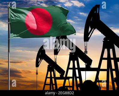 Ölbohrinseln vor dem Hintergrund des bunten Himmels und einer Fahnenstange mit der Flagge von Bangladesch. Das Konzept der Ölproduktion, Mineralien, Entwicklung von Stockfoto