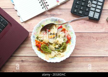 Frischer, hausgemachter Gemüsesalat auf dem Schreibtisch Stockfoto