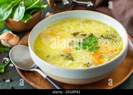 Frühlingsmenü. Gesunde Spinatsuppe mit Sahne auf einer dunklen Steinplatte. Stockfoto