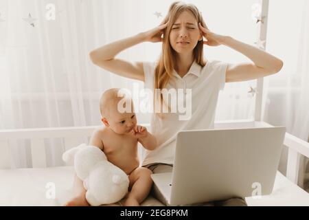 Müde verärgert Mutter verwendet Laptop versuchen, mit frechen kleinen Kind zu Hause arbeiten, Frau leidet Kopfschmerzen Stockfoto