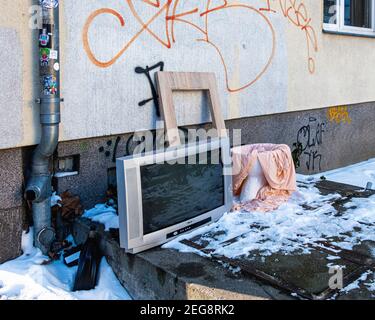 Fernseher und Porzellan Toilette gedumpt & aufgegeben auf einem schneebedeckten Stadtpflaster in Mitte, Berlin, Deutschland Stockfoto