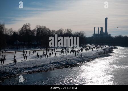 Menschen, die entlang der Isar Fluss Ufer genießen sonnigen Tag im Freien. Im Hintergrund ist ein Kraftwerk zu sehen. Stockfoto