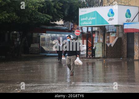 Gaza-Stadt, Palästina. Februar 2021, 18th. Ein Palästinenser geht am 18. Februar 2021, als es in Gaza-Stadt regnet. (Foto von Mahmoud Khattab/INA Photo Agency/Sipa USA) Quelle: SIPA USA/Alamy Live News Stockfoto