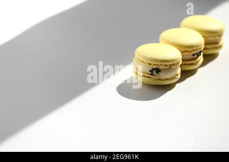 Süße gelbe Zitrone französisch Makronen oder Makronen Dessert isoliert auf weißem Hintergrund mit hellen Strahlen aus dem Fenster. Stockfoto