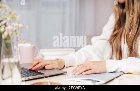 Frau schreibt im Notebook auf dem Schreibtisch mit Laptop Stockfoto