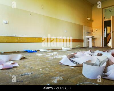 Alte Jalousien lagen auf schmutzigem Boden im alten verlassenen Krankenhaus Stockfoto