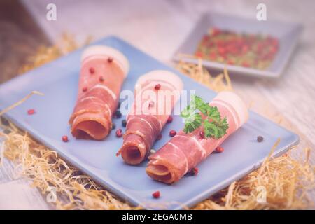 Schinkenscheiben mit Kräutern auf einem Tisch Stockfoto