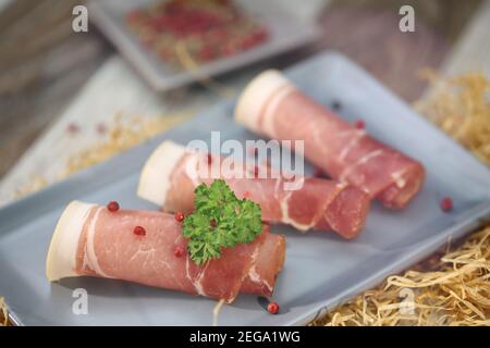 Schinkenscheiben mit Kräutern auf einem Tisch Stockfoto