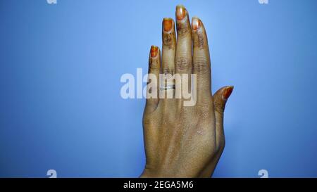 Weibliche Rückenhände isoliert auf weißem Hintergrund. Hand mit Ring und Mehandi oder Henna große Nägel Stockfoto