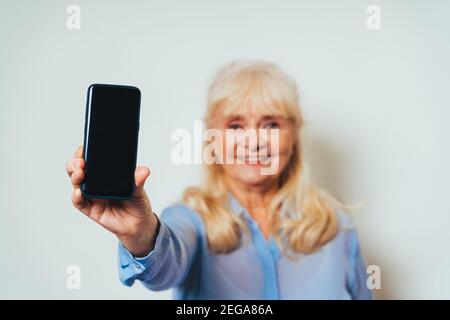 Schöne ältere Frau zu Hause und Blick auf Kamera lächelnd - ziemlich Erwachsene über 60 Jahre alt, Stockfoto