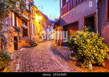 Nachtszene in den charmanten Straßen der befestigten Stadt Eguisheim, einem typischen Dorf in der elsässischen Weinregion von Frankreich. Stockfoto