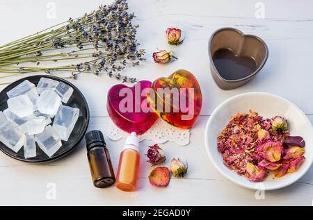 Herstellung handgemachte Seife mit kristallklarem Schmelz und gießen Seifenmischung. Bereit, rosa und gelb gebunden Seifen mit Rosenblättern und Lavendelblüten in verwenden Stockfoto