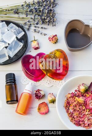 Herstellung handgemachte Seife mit kristallklarem Schmelz und gießen Seifenmischung. Bereit, rosa und gelb gebunden Seifen mit Rosenblättern und Lavendelblüten in verwenden Stockfoto