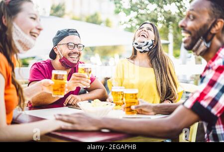 Junge Menschen trinken Bier mit offenen Gesichtsmasken - Neu Normales Lifestyle-Konzept mit Freund Spaß zusammen reden Happy Hour in der Brauerei Bar Stockfoto