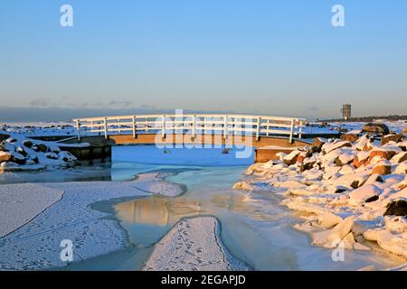 Holzbrücke, ein Teil der Wellenbrecher auf der Insel Särkkä, Helsinki, Finnland, an einem kalten und sonnigen Februarmorgen. Stockfoto