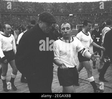 Vor 25 Jahren, am 23. Februar 1996, Helmut SCHOEN, deutsche Fußballnationalmannschaft, Bundesrepublik Deutschland - Schweden 1: 1, erstes Spiel unter dem neuen Bundestrainer Helmut SCHOEN (links), Schoen und Uwe SEELER gegen nach dem finalen Pfeifen gemeinsam aus dem Spielfeld, im Gespräch, s/w Aufnahme, Landschaftsformat, Mai 12, 1964. â Verwendung weltweit Stockfoto