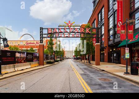 Ballpark Village Schild vor dem St. Louis Cardinals Busch Stadium des MLB mit Bars, Restaurants und dem Gateway Arch im Hintergrund. Stockfoto