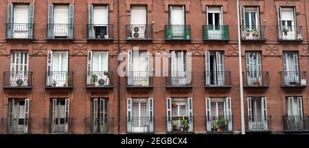 Rote Ziegelfassade mit schmiedeeisernen Balkonen in Madrid, Spanien Stockfoto