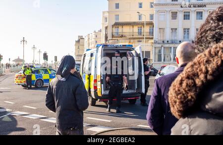 Brighton UK 18th February 2021 - EIN Mann (Gesicht wurde verpixelt) wird in einem Polizeiwagen festgehalten, während Polizeibeamte Brighton an der Küste schließen, nachdem sie ein Auto überfahren haben, das einen starken Verkehrsstau in der Stadt verursacht. Zwei Männer wurden verhaftet, nachdem das Auto unregelmäßig durch Sussex gefahren war, bevor es am Brighton Palace Pier angehalten wurde: Credit Simon Dack / Alamy Live News Stockfoto