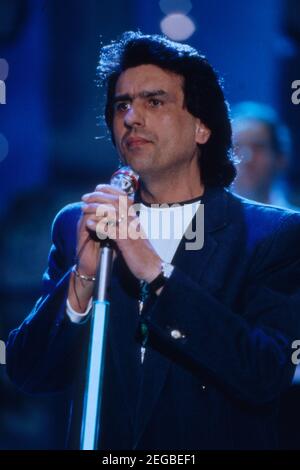 Toto Cutugno, Salvatore Cutugno, italienischer Sänger und Songwriter, während eines TV-Auftritts, 1990. Toto Cutugno, alias Salvatore Cutugno, italienischer Sänger und Songwriter, während einer TV-Performance, 1990. Stockfoto