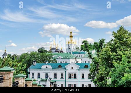 goldene Kuppeln und ein Kreuz der orthodoxen Kirche gegen den blauen Himmel, an einem warmen Sommertag Ukraine, Kiew Stockfoto