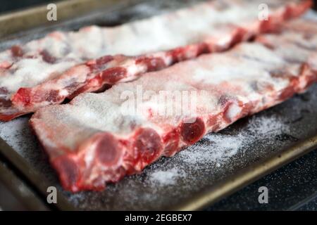 Schweinefleisch Spare Rippen mit Salz bedeckt, trocken einbräunend, die nach einer Stunde oder so vor dem Kochen abgewaschen wird Stockfoto