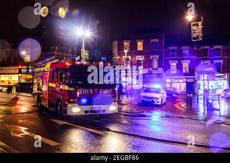Ein Feuerwehrauto und ein Polizeiauto, das an einem Zwischenfall in einer Winternacht in Crouch End, London, Großbritannien, teilnahm Stockfoto