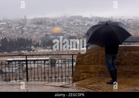 Jerusalem, Israel. Februar 2021, 18th. Am Donnerstag, den 18. Februar 2021, schaut ein Mann auf den Schnee auf dem Felsendom im Al Aqsa-Moschee-Gelände in der Altstadt Jerusalems. Foto von Debbie Hill/UPI Kredit: UPI/Alamy Live Nachrichten Stockfoto