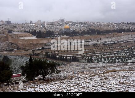 Jerusalem, Israel. Februar 2021, 18th. Schnee bedeckt den jüdischen Friedhof auf dem Ölberg mit Blick auf den Felsendom auf dem Al Aqsa-Moschee-Gelände in der Altstadt von Jerusalem, am Donnerstag, den 18. Februar 2021. Foto von Debbie Hill/UPI Kredit: UPI/Alamy Live Nachrichten Stockfoto