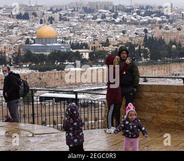 Jerusalem, Israel. Februar 2021, 18th. Palästinenser nehmen am Donnerstag, den 18. Februar 2021, einen Selfi mit Schnee auf dem Felsendom auf dem Al Aqsa-Moschee-Gelände in der Altstadt von Jerusalem. Foto von Debbie Hill/UPI Kredit: UPI/Alamy Live Nachrichten Stockfoto