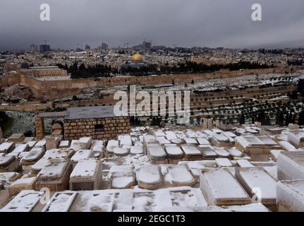 Jerusalem, Israel. Februar 2021, 18th. Schnee bedeckt den jüdischen Friedhof auf dem Ölberg mit Blick auf den Felsendom auf dem Al Aqsa-Moschee-Gelände in der Altstadt von Jerusalem, am Donnerstag, den 18. Februar 2021. Foto von Debbie Hill/UPI Kredit: UPI/Alamy Live Nachrichten Stockfoto