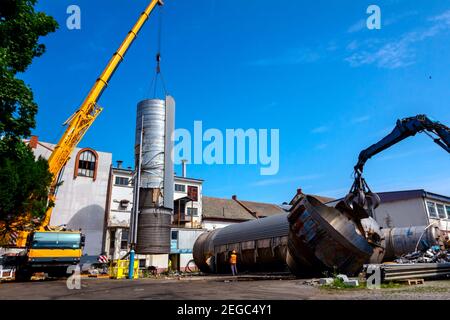 Lader Maschinen mit hydraulischer grappling Klaue und Kran sind die heavy metal Silo in industriellen Komplexes. Stockfoto